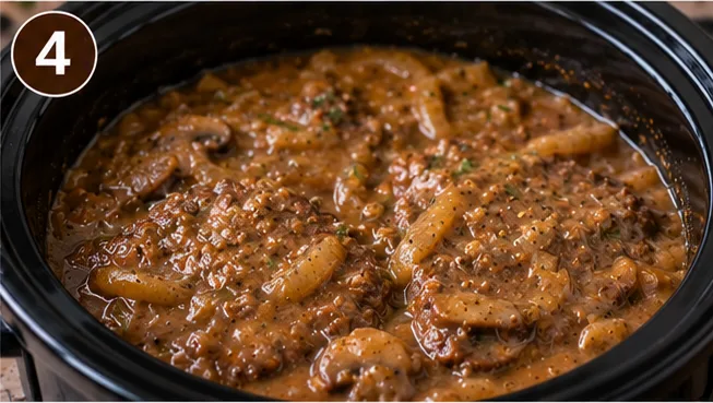 Cooked cube steak in a thickened mushroom gravy in the slow cooker
