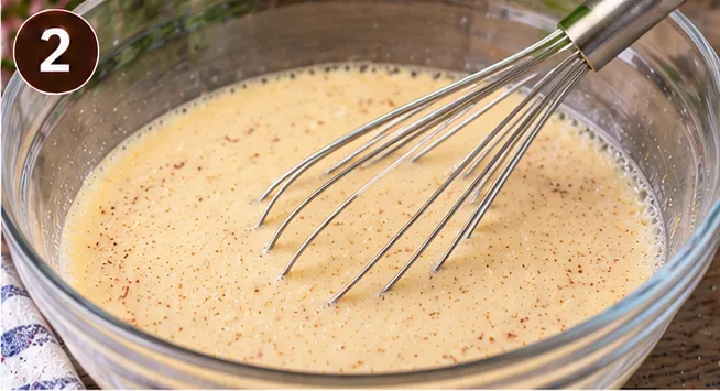 Custard mixture whisked together in a glass bowl