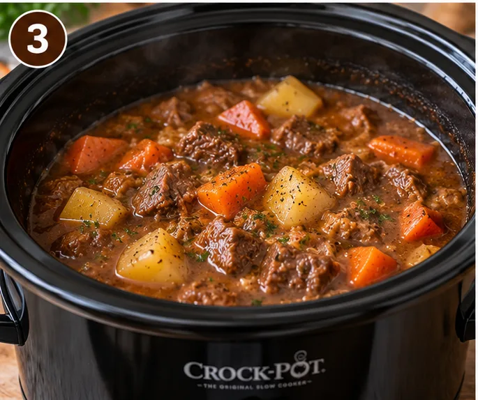 Slow cooker mulligan stew fully cooked, with beef, potatoes, and carrots in a thickened gravy