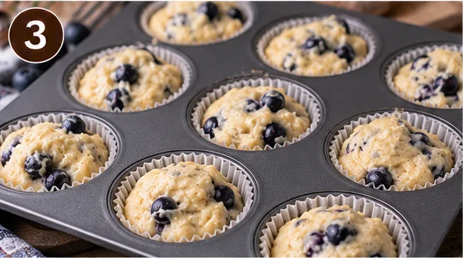 Unbaked blueberry muffin batter divided into a muffin tin